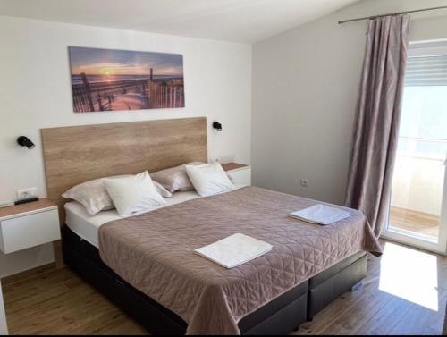 a bedroom with a bed with two towels on it at Apartments SKY in Brela