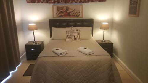 ein Schlafzimmer mit einem Bett mit zwei Handtüchern darauf in der Unterkunft Beachway Guesthouse in Port Elizabeth