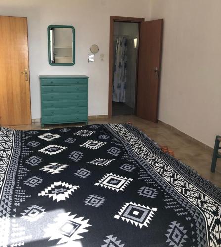 ein Schlafzimmer mit einem Bett und einem schwarz-weißen Teppich in der Unterkunft Vromolithos view in Vromolithos