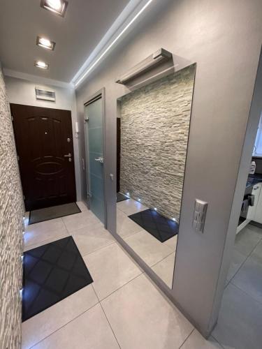 a hallway with a mirror next to a door at Apartament Ala in Zabrze
