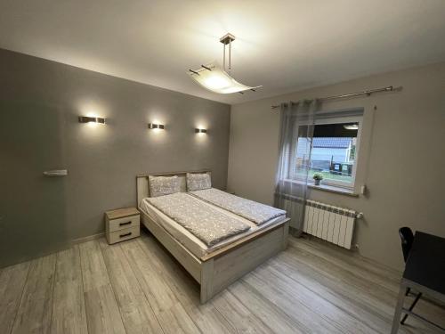 a bedroom with a bed and a window at Apartament Ala in Zabrze