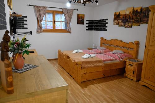 a bedroom with a wooden bed with red pillows at Zbojnicky penzion in Jasenica