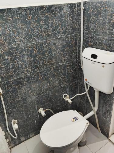 a bathroom with a white toilet in a room at Hotel Shree Sanwaliya INN in Ayodhya