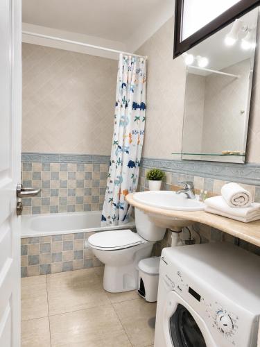a bathroom with a toilet sink and a washing machine at Fwt Relax Bungalow in Playa de las Americas