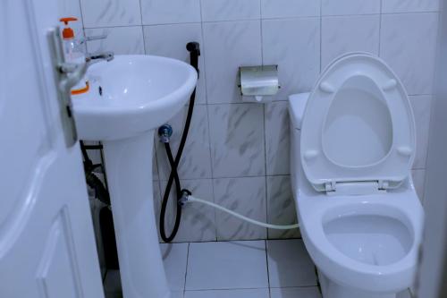 a bathroom with a white toilet and a sink at Ziwani House in Mwanza