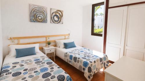 a bedroom with two beds and a window at Fwt Relax Bungalow in Playa de las Americas