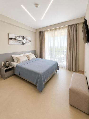 a bedroom with a bed and a large window at Villa Olivia Skioni in Nea Skioni