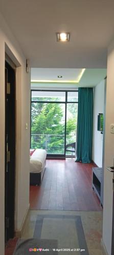 a bedroom with a bed and a large window at Hotel San Andreas Amar in Kodaikānāl