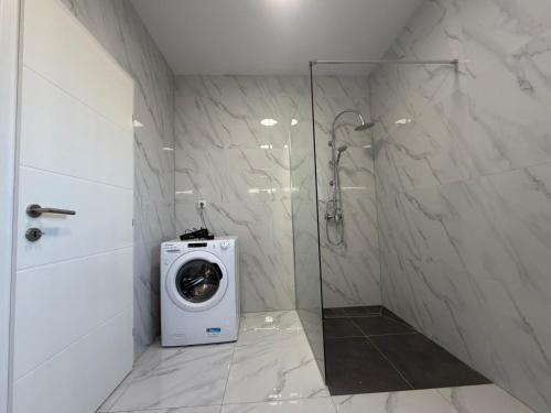 a bathroom with a washing machine in a shower at Vila Gaia in Sarajevo