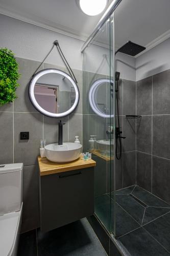 a bathroom with a sink and a shower with a mirror at APART-HOTEl 95 in Almaty