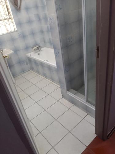 a bathroom with a shower and a bath tub at Star Contractors Accodation with self catering in Mahikeng