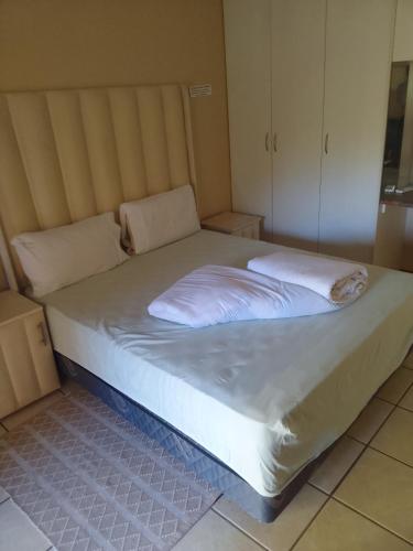 a bed with two pillows on it in a room at Star Contractors Accodation with self catering in Mahikeng