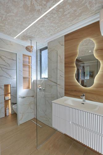 a bathroom with a sink and a mirror at Ilio Boutique Hotel in Ksamil