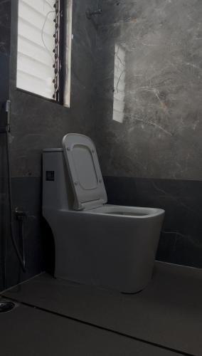a white toilet in a bathroom with a window at Nasa in Panchanai