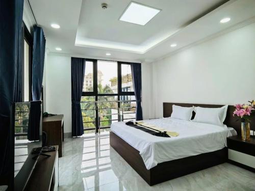 a bedroom with a large bed and a large window at Army Hotel in Yen