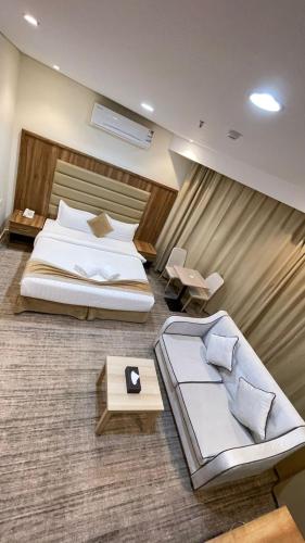 a large bedroom with two beds and a table at دولف للشقق الفندقية حي المصيف in Hail