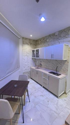 a kitchen with a table and a dining room at دولف للشقق الفندقية حي المصيف in Hail