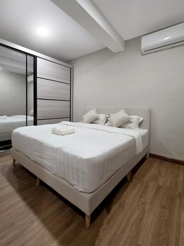 a bedroom with a large white bed with white sheets at Juichi Homestay in Kluang
