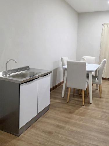 a kitchen with a sink and a table with chairs at Juichi Homestay in Kluang