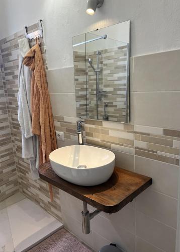a bathroom with a white sink on a wooden counter at Antoni House in Bulzi