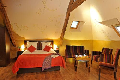 a bedroom with a bed and a table and chairs at Hotel O2B Aux Berges de Brocéliande in Beignon