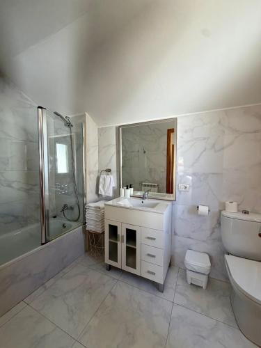 a bathroom with a sink and a shower and a toilet at PortoHome 2 in Portomarin