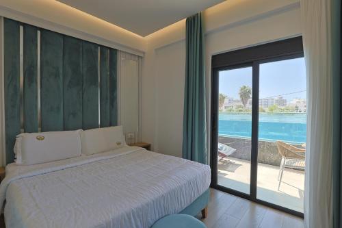 a bedroom with a bed and a view of a pool at Ilio Boutique Hotel in Ksamil