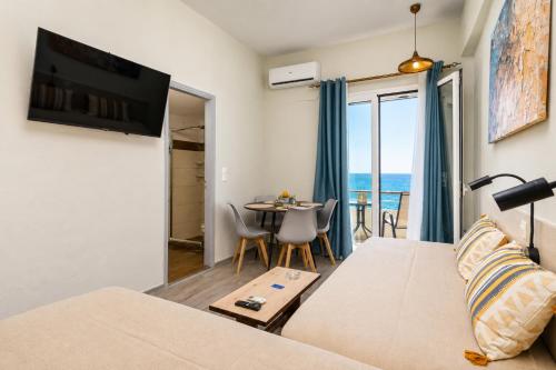 a living room with a couch and a table at Sole e Mare B2 Beachfront Sea View Apartment in Koutsourás