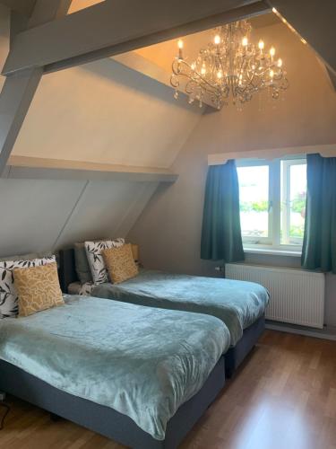 a bedroom with two beds and a chandelier at Bed en Breakfast 1394 in Nederhorst den Berg