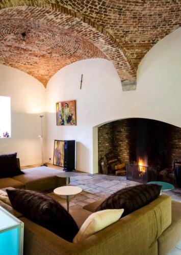 a living room with a large couch and a fireplace at The Grand Indradhar Resort Dharamshala in Dharamshala