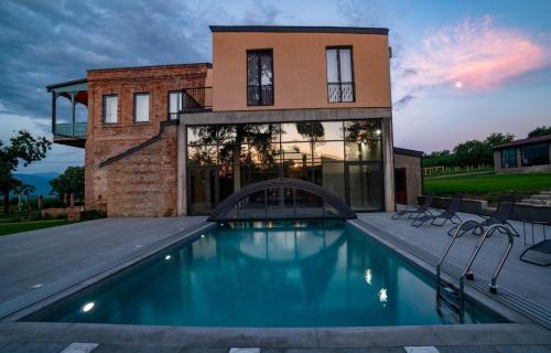 a house with a swimming pool in front of a building at Two&Half Qvevri in Telavi