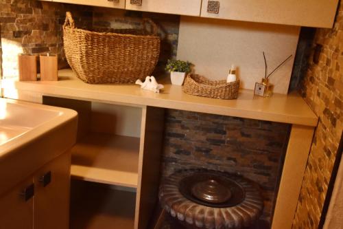 a kitchen counter with a brick wall and a sink at Villa Fümehan Tarihi Rum Taş Ev Since 1820 in Kayakoy