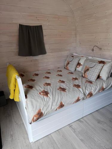 a bed in a bedroom with chickens on the sheets at Kelp Drift, Coastal Pod, near Oldshoremore Beach in Rhiconich