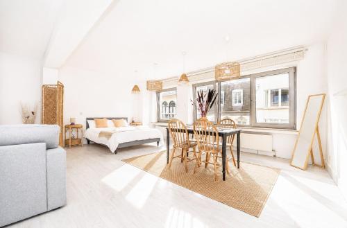 a white living room with a table and chairs at Grand Rue Studio - sleeps 5 in Luxembourg
