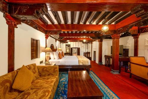 a hotel room with a bed and a couch at Fort JadhavGADH -A GADH Heritage Hotel in Pune