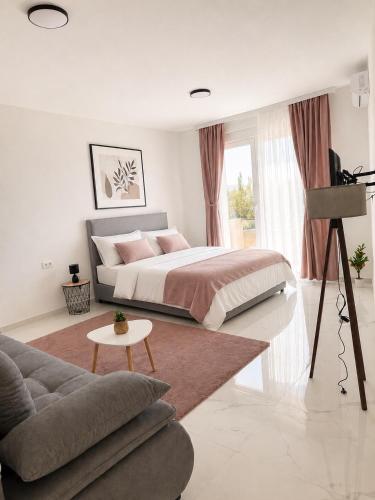a bedroom with a large bed and a couch at MangaRenga apartments in Šušanj