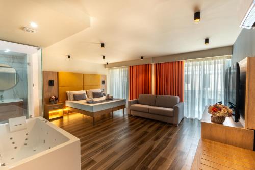 a living room with a tub and a couch at C'est La Vie Hotel Marsascala in Marsaskala