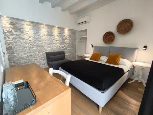 a bedroom with a bed and a chair and a table at La Maison in Trani