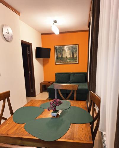 a living room with a table and a green couch at St Ivan Rilski Private Apartment - 4 stars SPA - Slopes View in Bansko