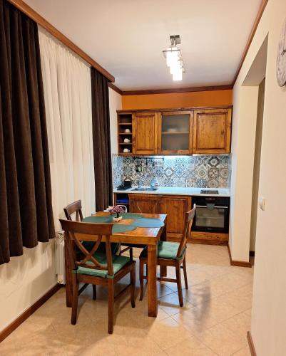 a kitchen with a wooden table and chairs in a room at St Ivan Rilski Private Apartment - 4 stars SPA - Slopes View in Bansko