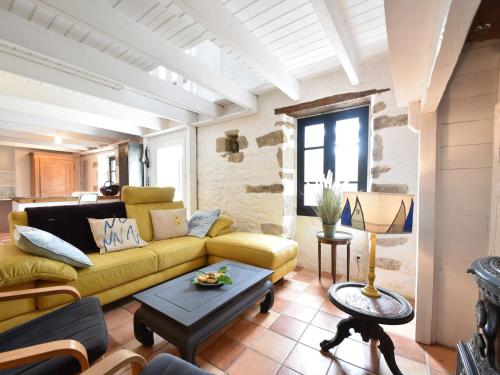 a living room with a yellow couch and a table at Brittany Escape with Garden in Kersaudy