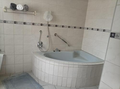 a bath tub with a shower in a bathroom at Stay with Tayo in Kempton Park