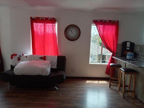 a living room with red curtains and a couch at Stay with Tayo in Kempton Park