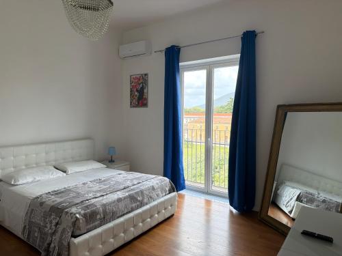 a bedroom with a bed and a mirror and a window at Terrazza Vanvitelli in Caserta