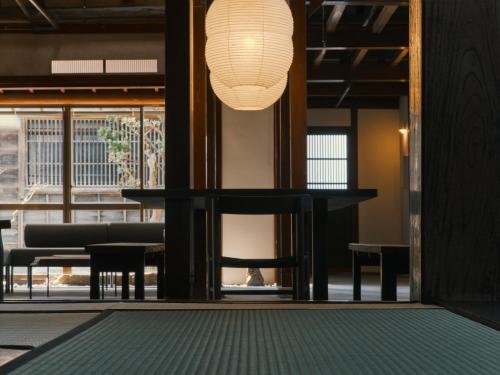 a room with a table and chairs and a lamp at 安宅ノ宿 沖 in Komatsu