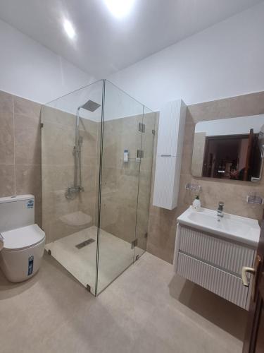 a bathroom with a shower and a toilet and a sink at Casa olivos villa 100m de la plage in Al Hoceïma