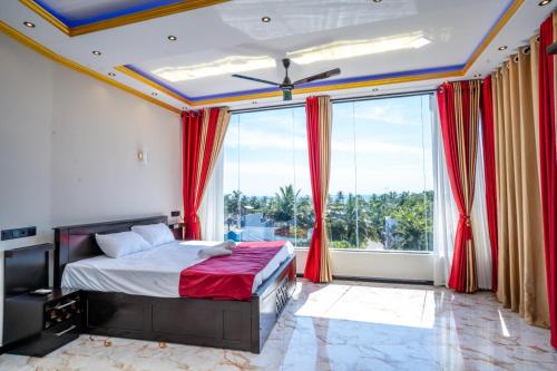 a bedroom with a bed and a large window at RR complex in Trincomalee