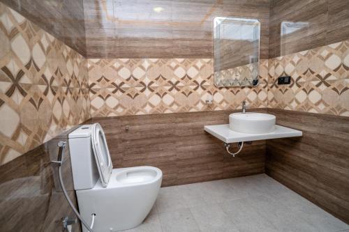 a bathroom with a toilet and a sink at RR complex in Trincomalee