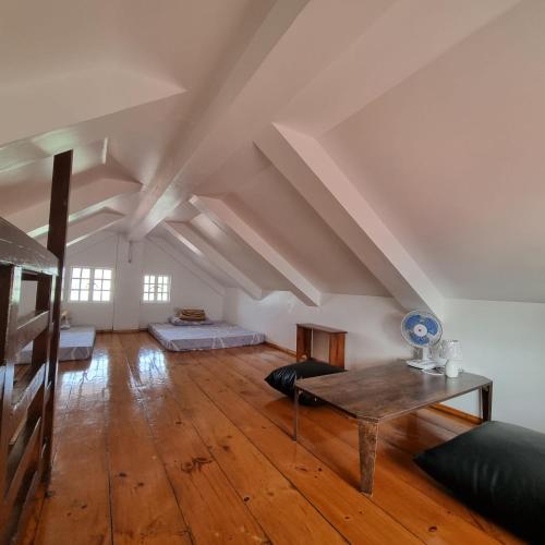 an attic room with a table and a bed at Whyte Pyne Transient House in Baguio