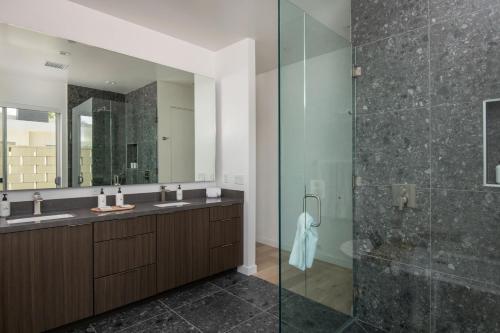 a bathroom with two sinks and a glass shower at Mercury @ Elemento49 - Pool Spa - Sleeps 16 in Indio
